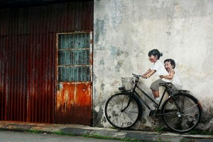 A mural of two children on a bicycle.