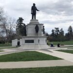 A statue of a man in the middle of a park.