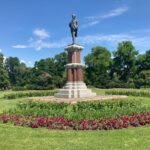 A statue of a man in the middle of a garden.